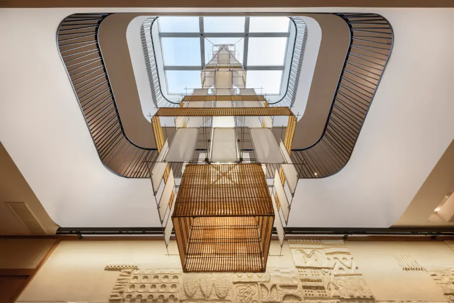 Vista ascendente de un atrio con dise&ntilde;o moderno y techo de cristal.