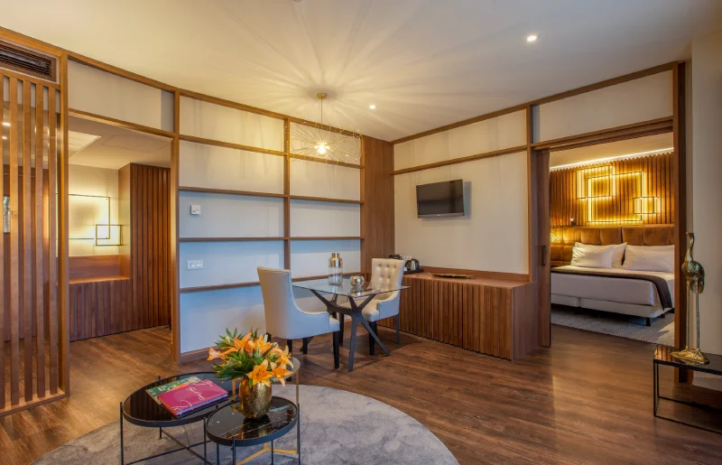 Sala moderna con muebles de madera, &aacute;rea de descanso y detalles decorativos.