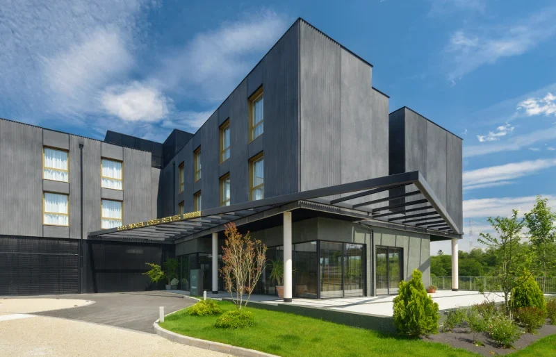 Edificio moderno con jard&iacute;n y cielo despejado.