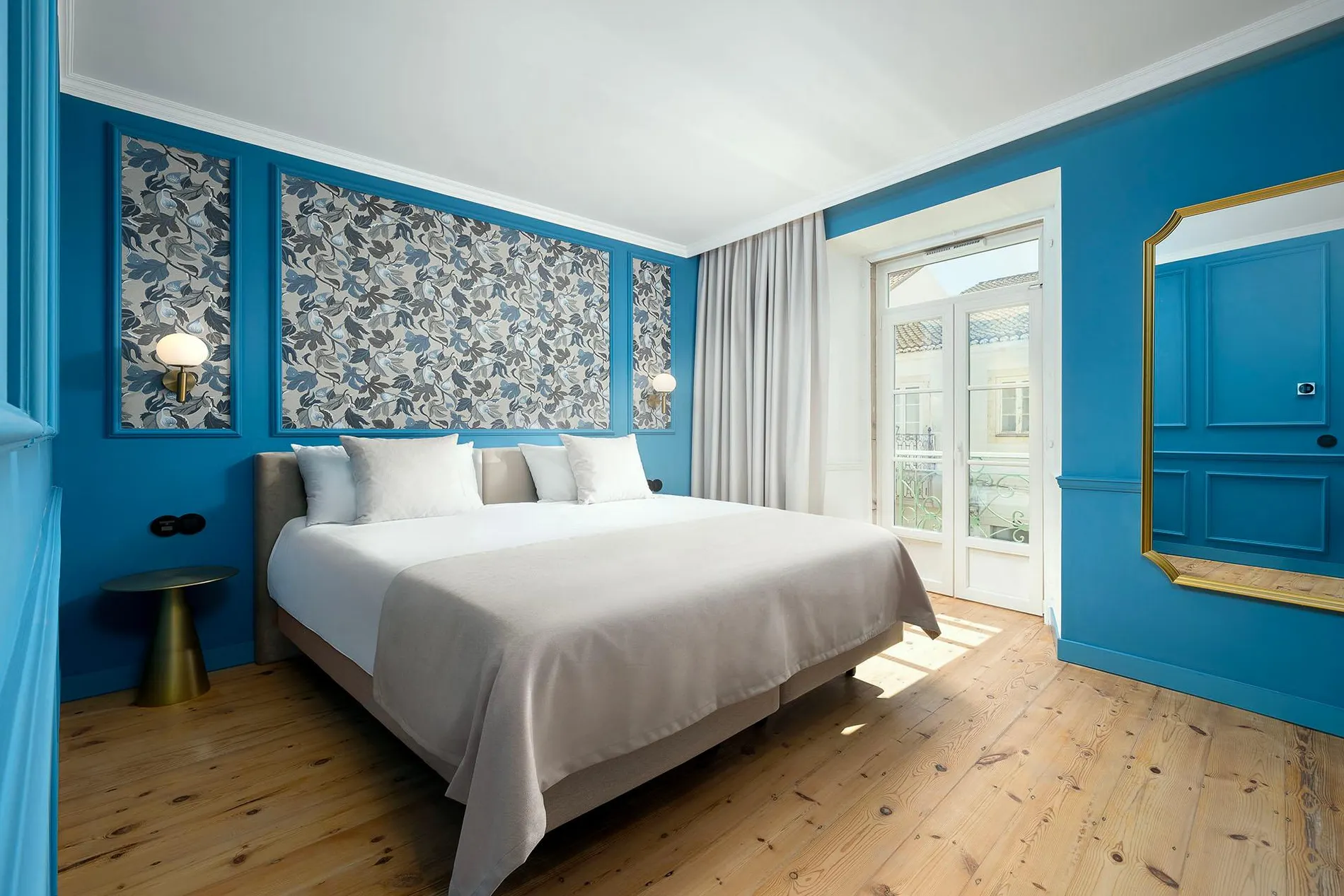 Quarto moderno com papel de parede floral e paredes azuis.