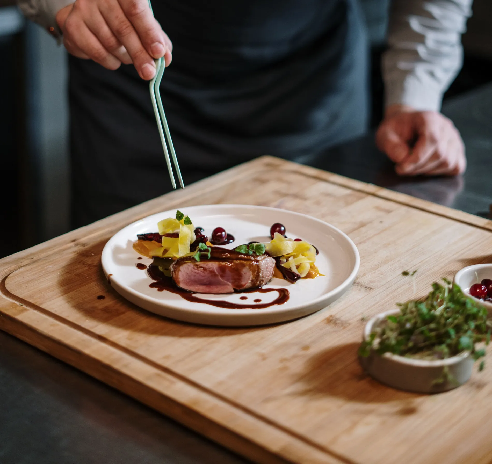 Chef emplaca uma refei&ccedil;&atilde;o gourmet decorada com molho e frutas.