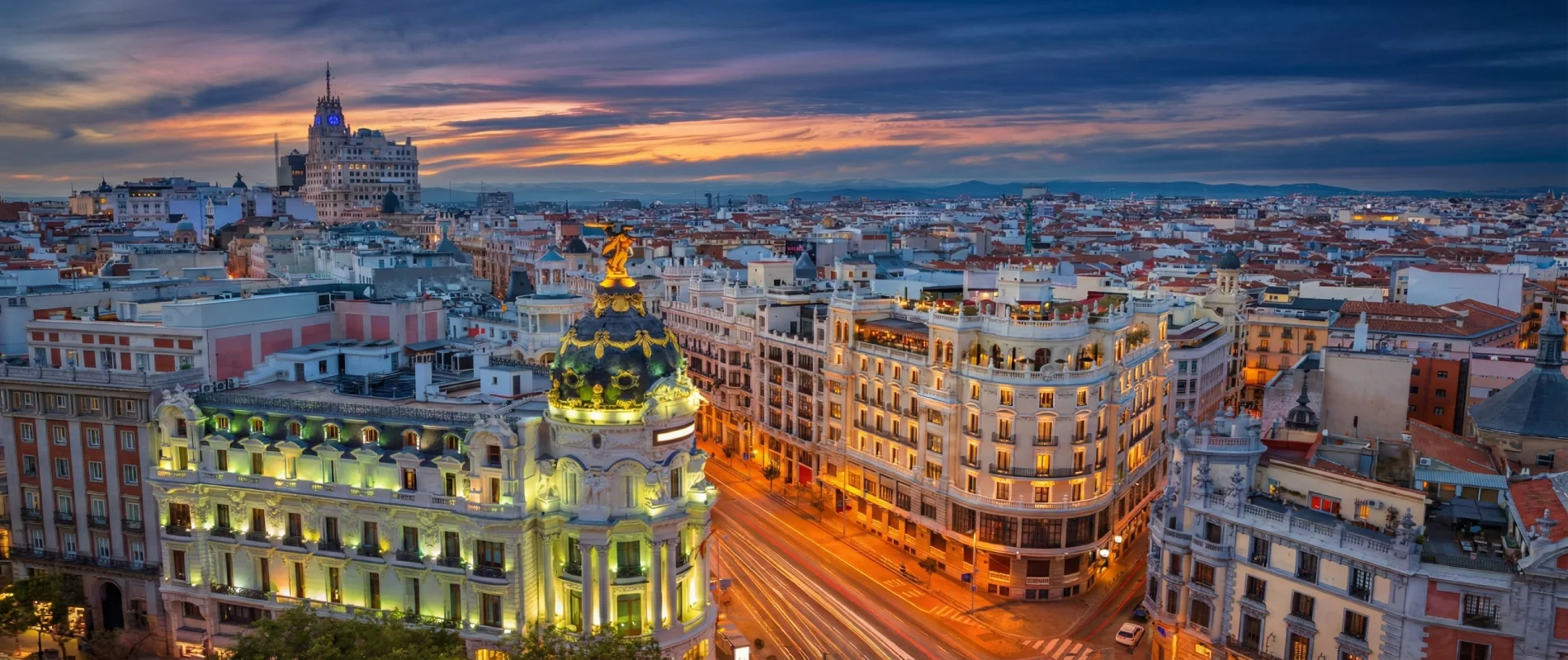 Vista nocturna de un edificio ic&oacute;nico en una ciudad con un cielo atardecido.
