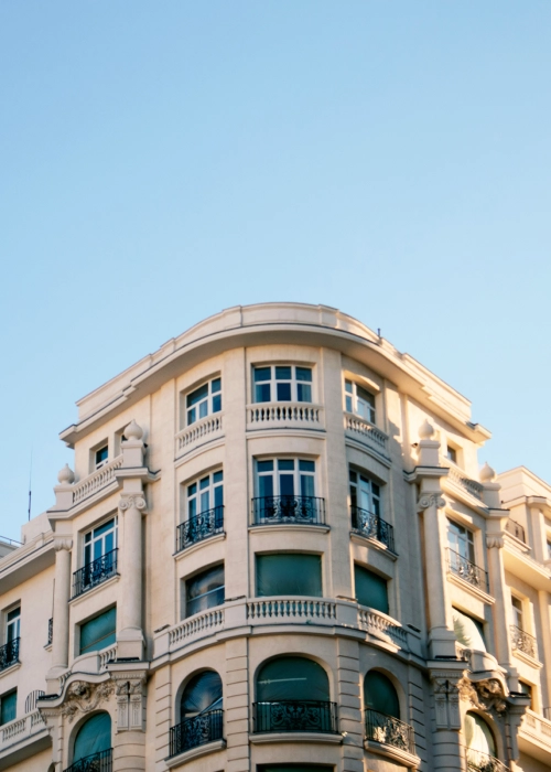 Edificio con fachada cl&aacute;sica y cielo despejado.