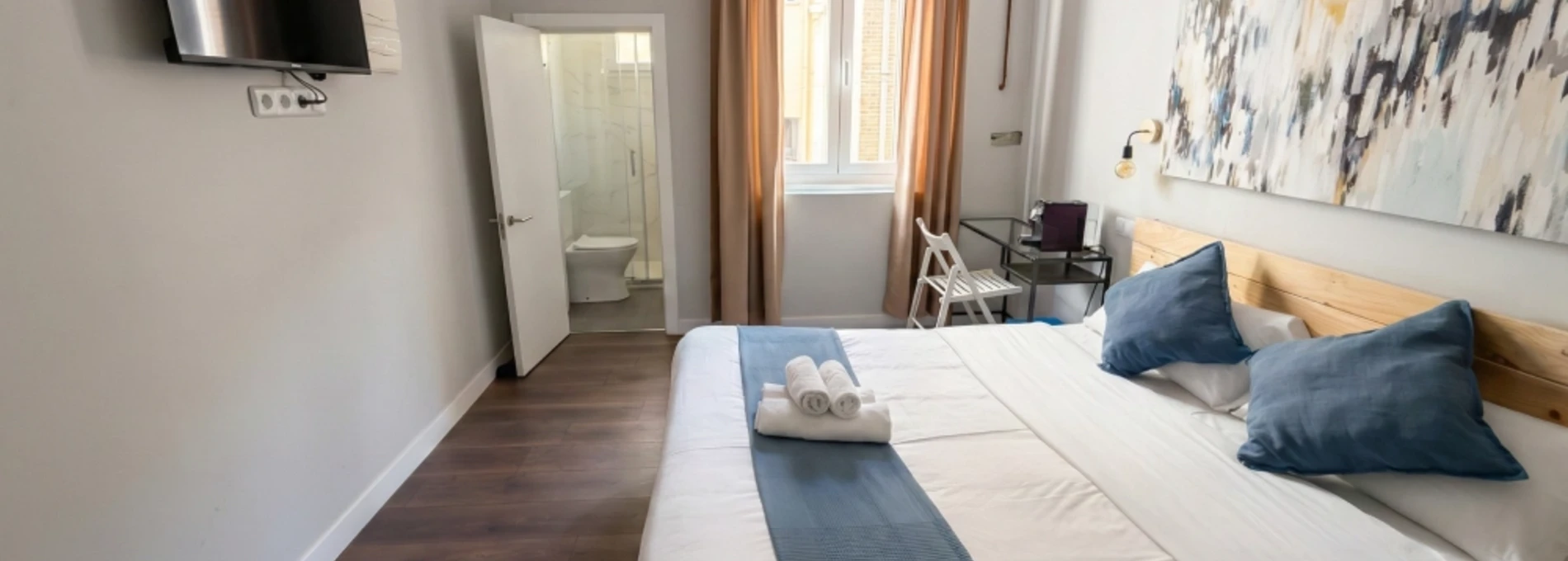 Habitaci&oacute;n de hotel moderna con cama amplia y ba&ntilde;o privado.