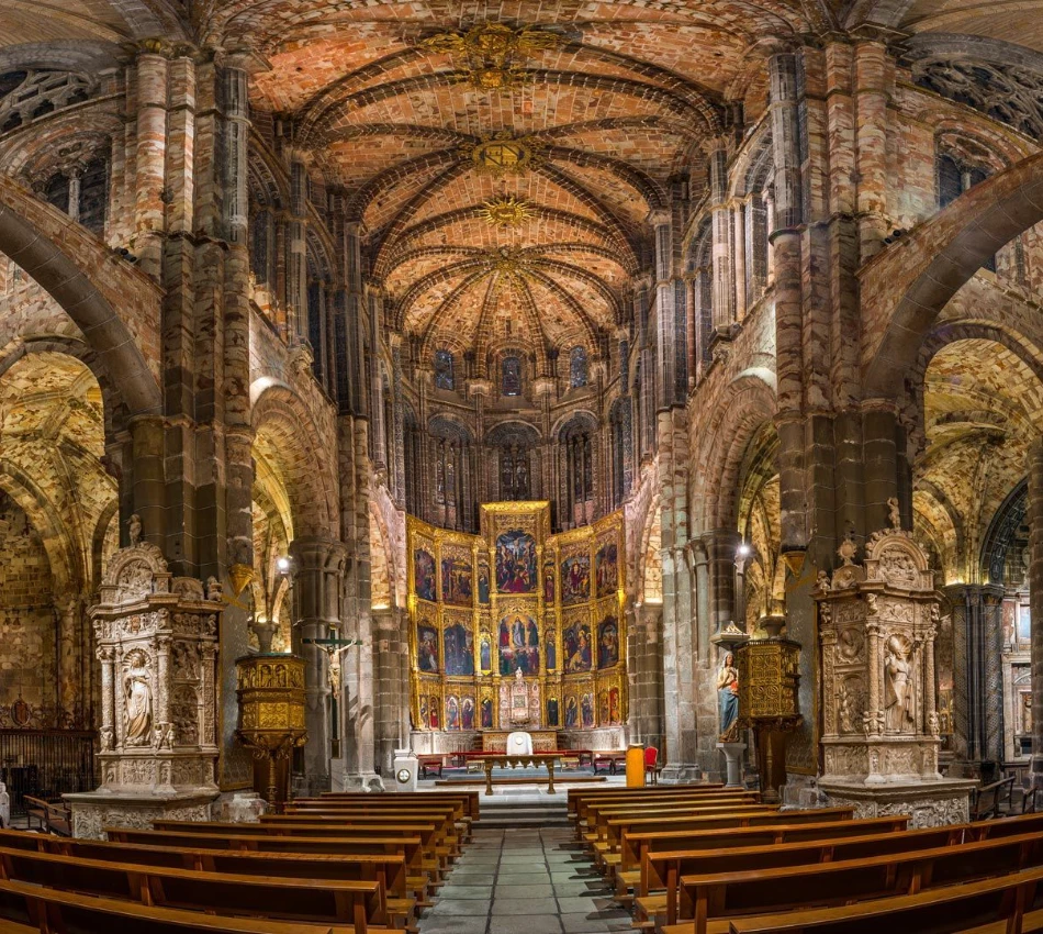 Catedral g&oacute;tica con altar adornado, techos abovedados y bancos de madera.
