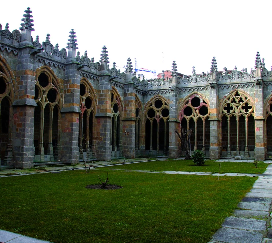 Claustro medieval con arcos g&oacute;ticos y jard&iacute;n en el centro.