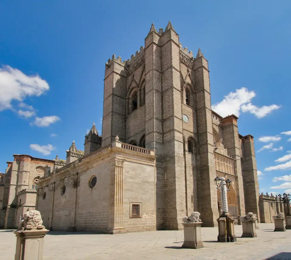 Catedral g&oacute;tica con cielo despejado y esculturas de leones en el exterior.