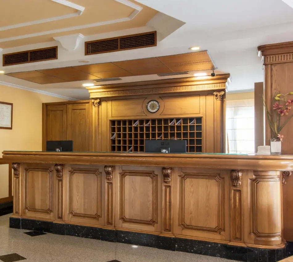 Recepci&oacute;n de hotel con mostrador de madera.
