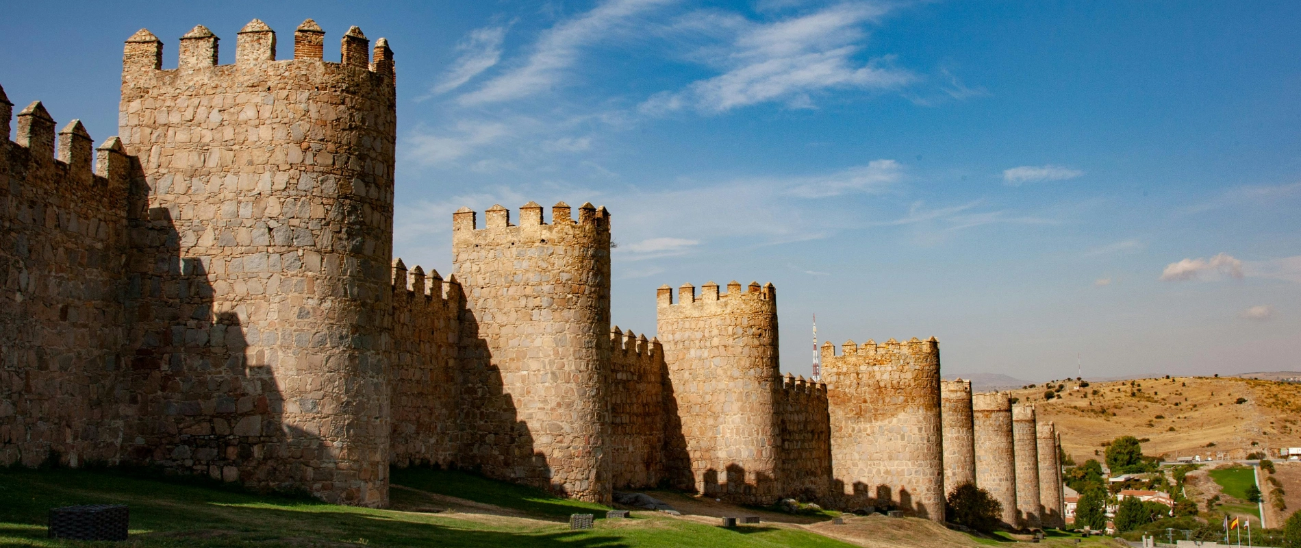Muralla antigua bajo un cielo azul con algunas nubes.