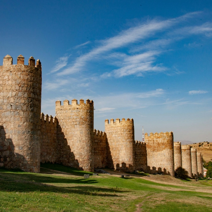 Murallas de piedra bajo un cielo azul con nubes dispersas.