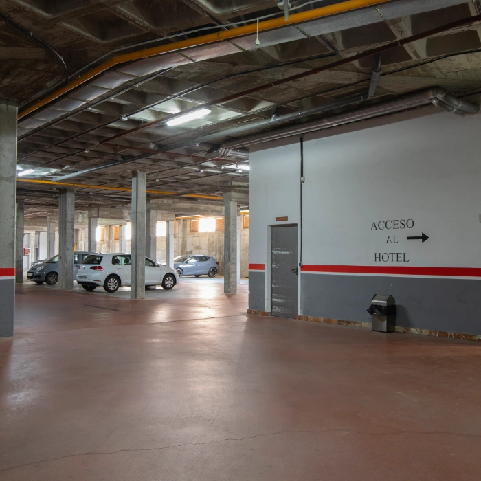 Estacionamiento subterr&aacute;neo con se&ntilde;al hacia el acceso al hotel.