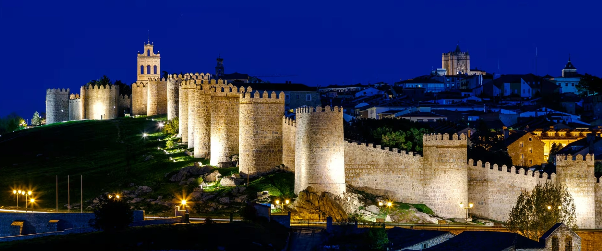Murallas iluminadas de una ciudad hist&oacute;rica bajo el cielo nocturno.