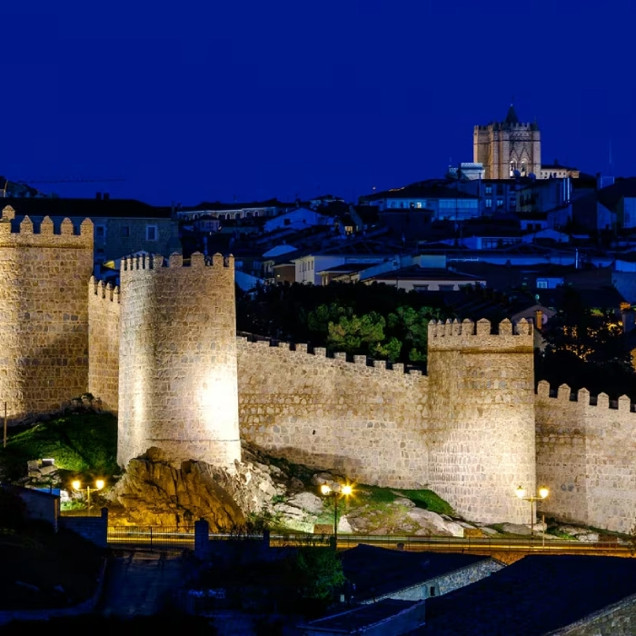 Murallas iluminadas de una ciudad al anochecer.