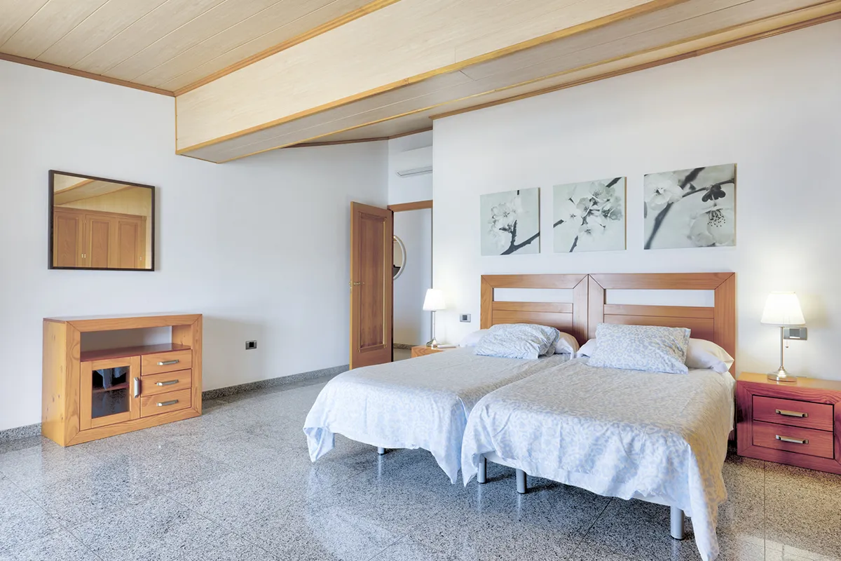 Habitación con dos camas, decoración minimalista y muebles de madera.