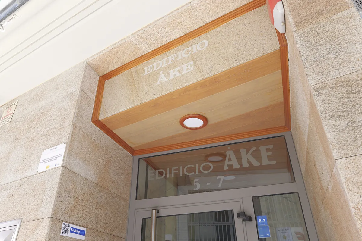 Entrada del Edificio Áke, fachada de piedra y puerta de vidrio.