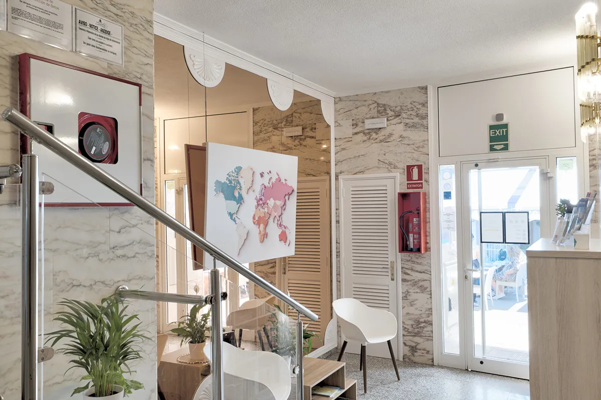 Interior de una recepción con mapa, sillas y extintor visible.