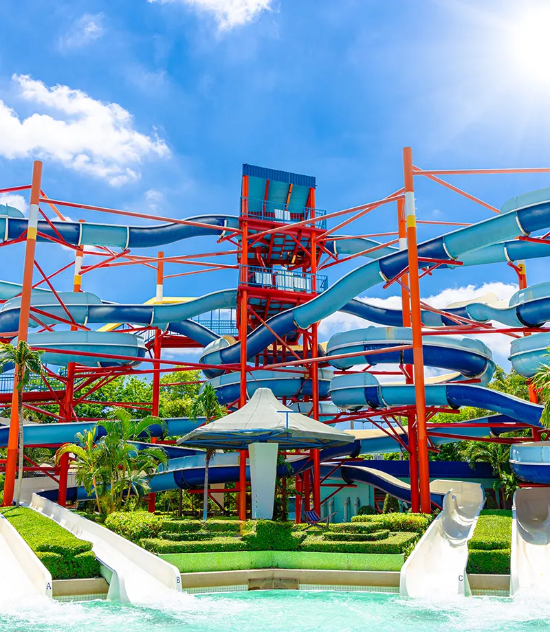 Toboganes acu&aacute;ticos en un parque bajo un cielo soleado y azul.