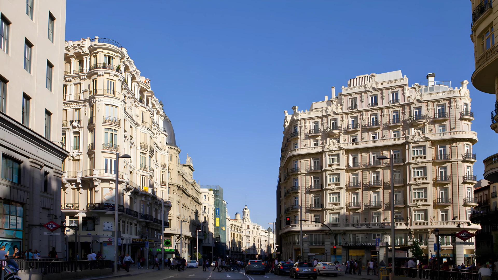 Calle concurrida con edificios hist&oacute;ricos y cielo azul claro.