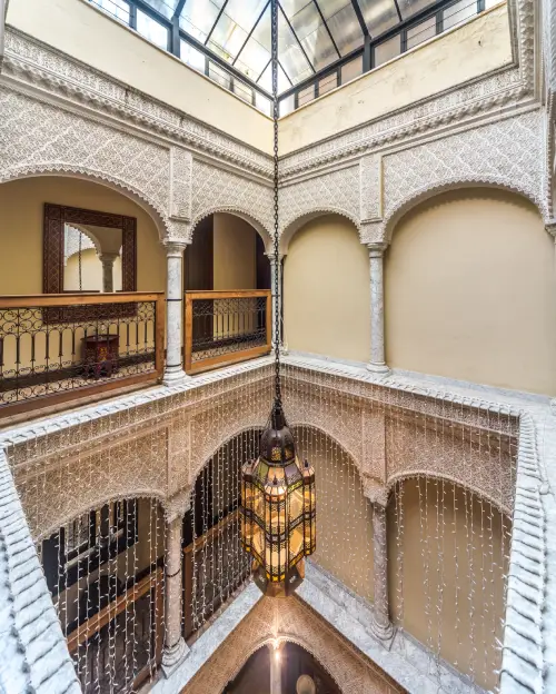 Patio con columnas y l&aacute;mpara colgante, estilo arquitect&oacute;nico &aacute;rabe.