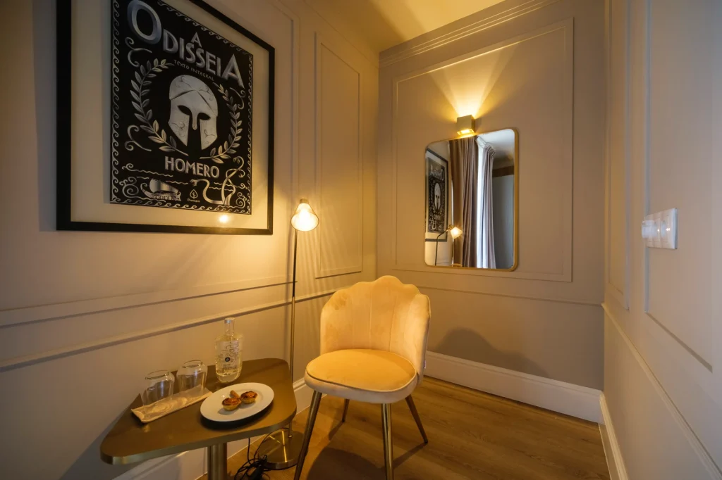 Sala de leitura aconchegante com poltrona, mesa e lumin&aacute;ria.