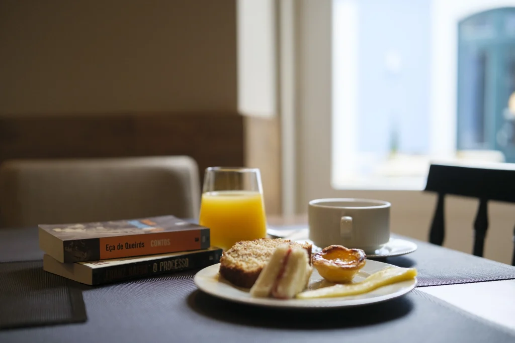 Livros, caf&eacute;, suco e doces sobre a mesa.