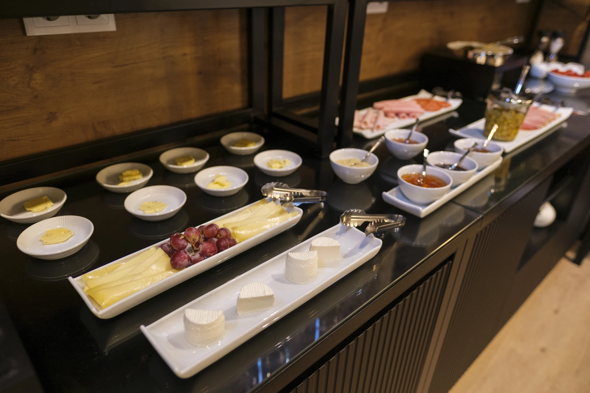 Buffet de caf&eacute; da manh&atilde; com queijos, uvas e frios.