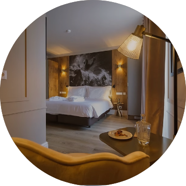 Quarto de hotel aconchegante com cama, poltrona e mesa.