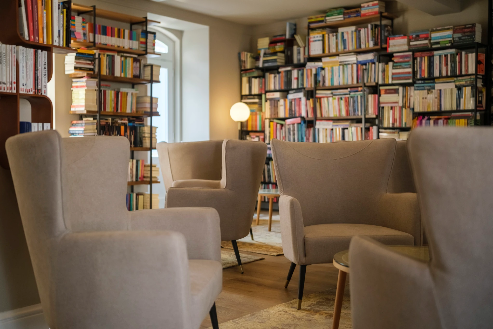 Sala de leitura aconchegante com poltronas e estantes de livros.