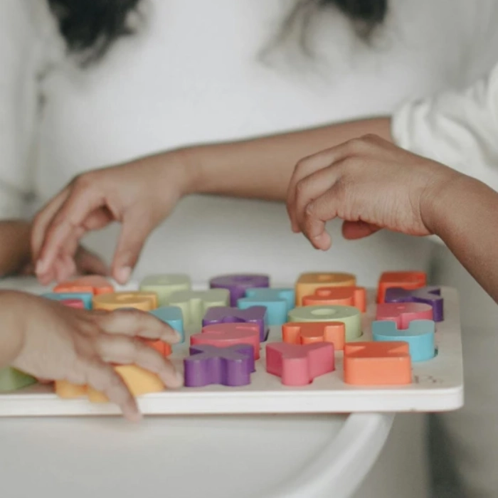 Crian&ccedil;as brincam com quebra-cabe&ccedil;a de letras coloridas.