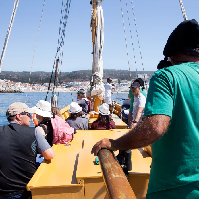 Pessoas em um barco velejando em dia ensolarado.
