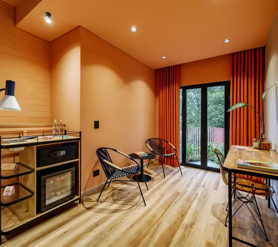 Sala moderna y luminosa con sillones, mesa y decoraci&oacute;n en tonos naranjas.