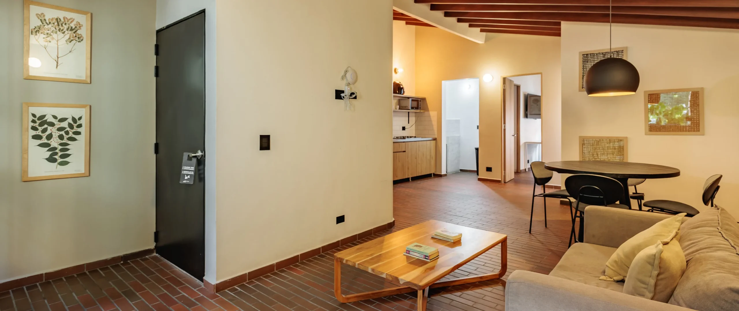 Sala acogedora con mesa de centro, comedor y cocina al fondo.