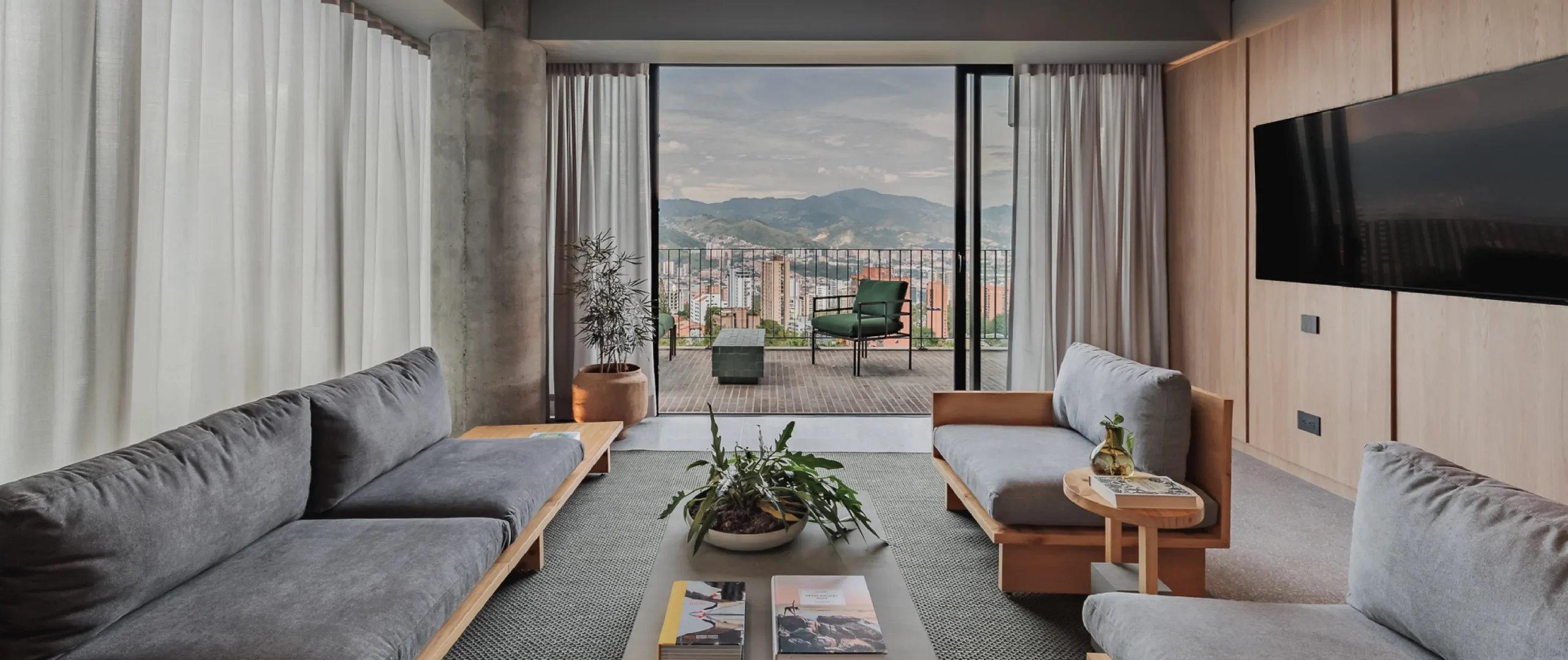 Sala moderna con vista a la monta&ntilde;a desde un balc&oacute;n, luces y decoraciones.