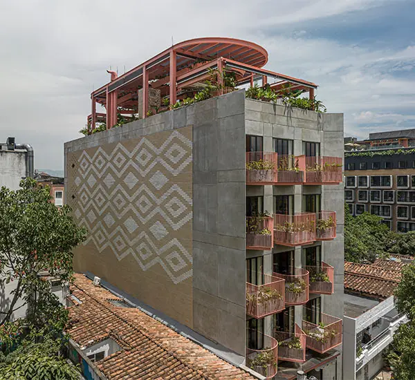 Edificio moderno con balcones y terraza verde en la azotea, dise&ntilde;o geom&eacute;trico.