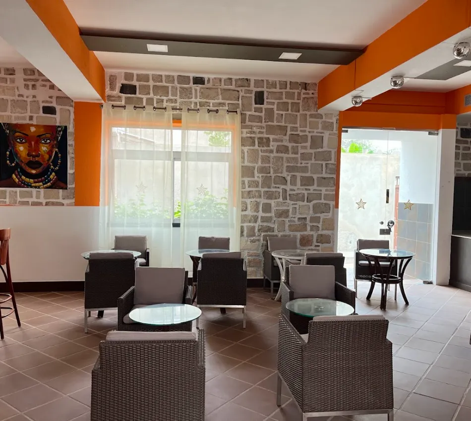 Caf&eacute; acolhedor com paredes de pedra, arte vibrante e mobili&aacute;rio de vime em estilo moderno.