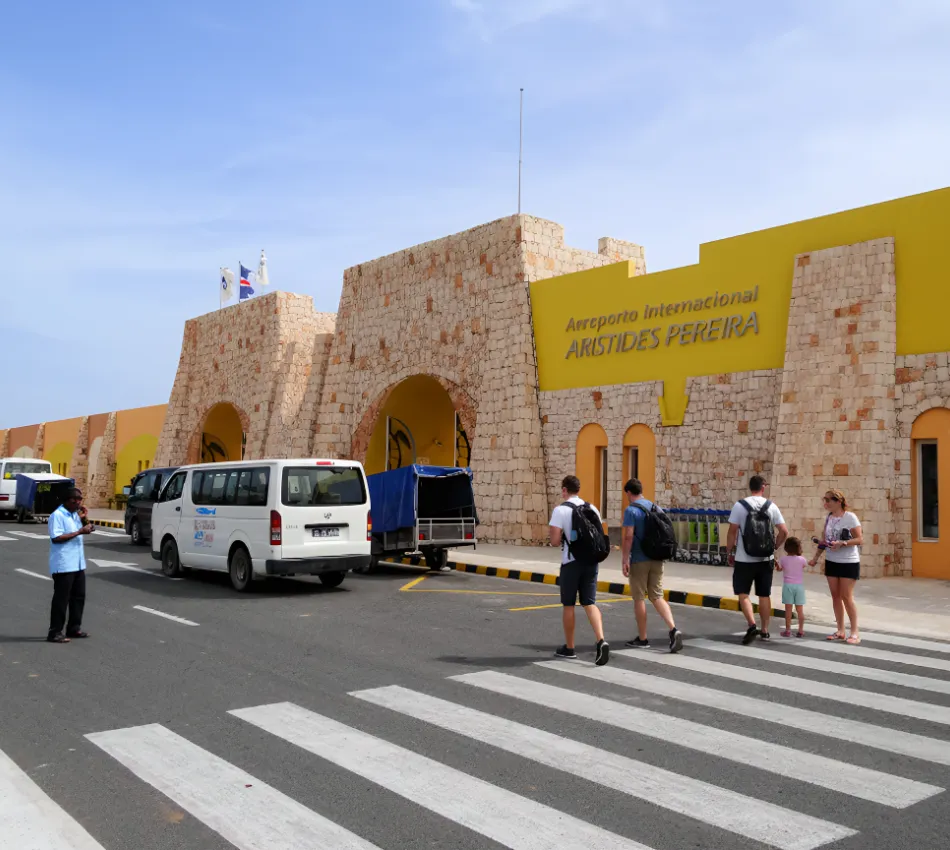 Pessoas cruzam a faixa em frente ao Aeroporto Internacional Aristides Pereira.