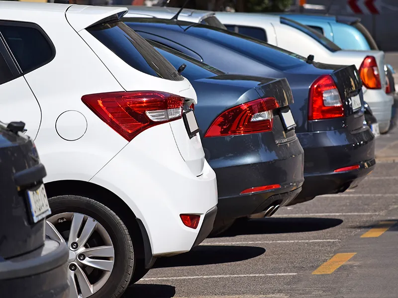 Coches estacionados en fila en un aparcamiento.