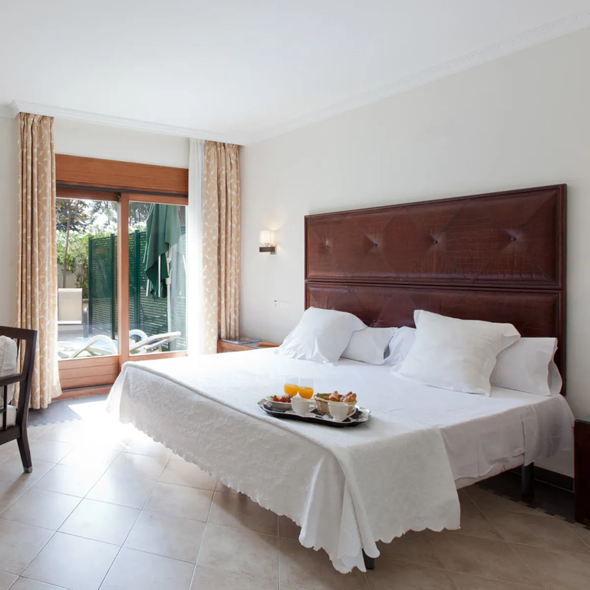Habitaci&oacute;n luminosa con cama doble y desayuno en bandeja.