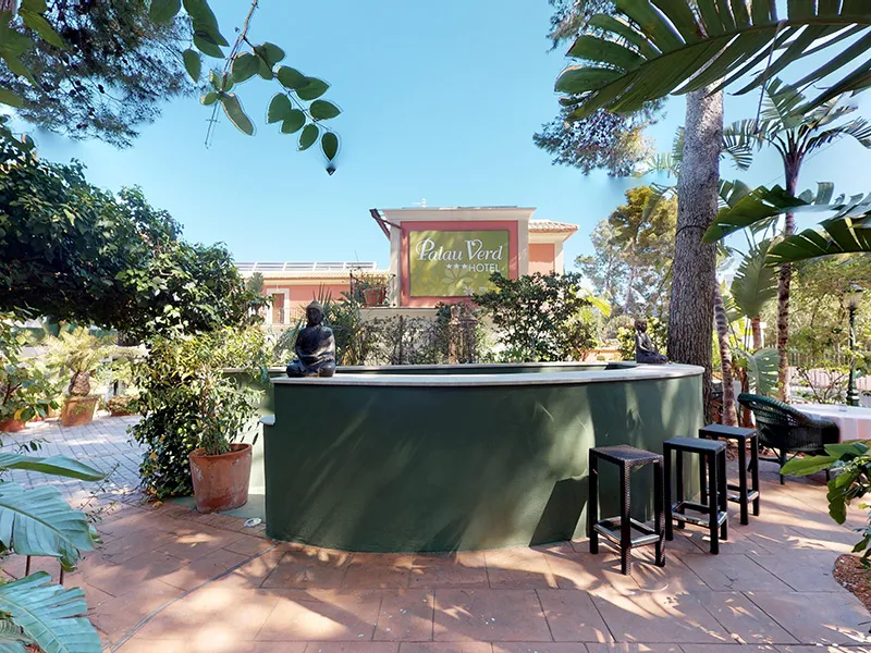 Bar al aire libre rodeado de plantas en un hotel.