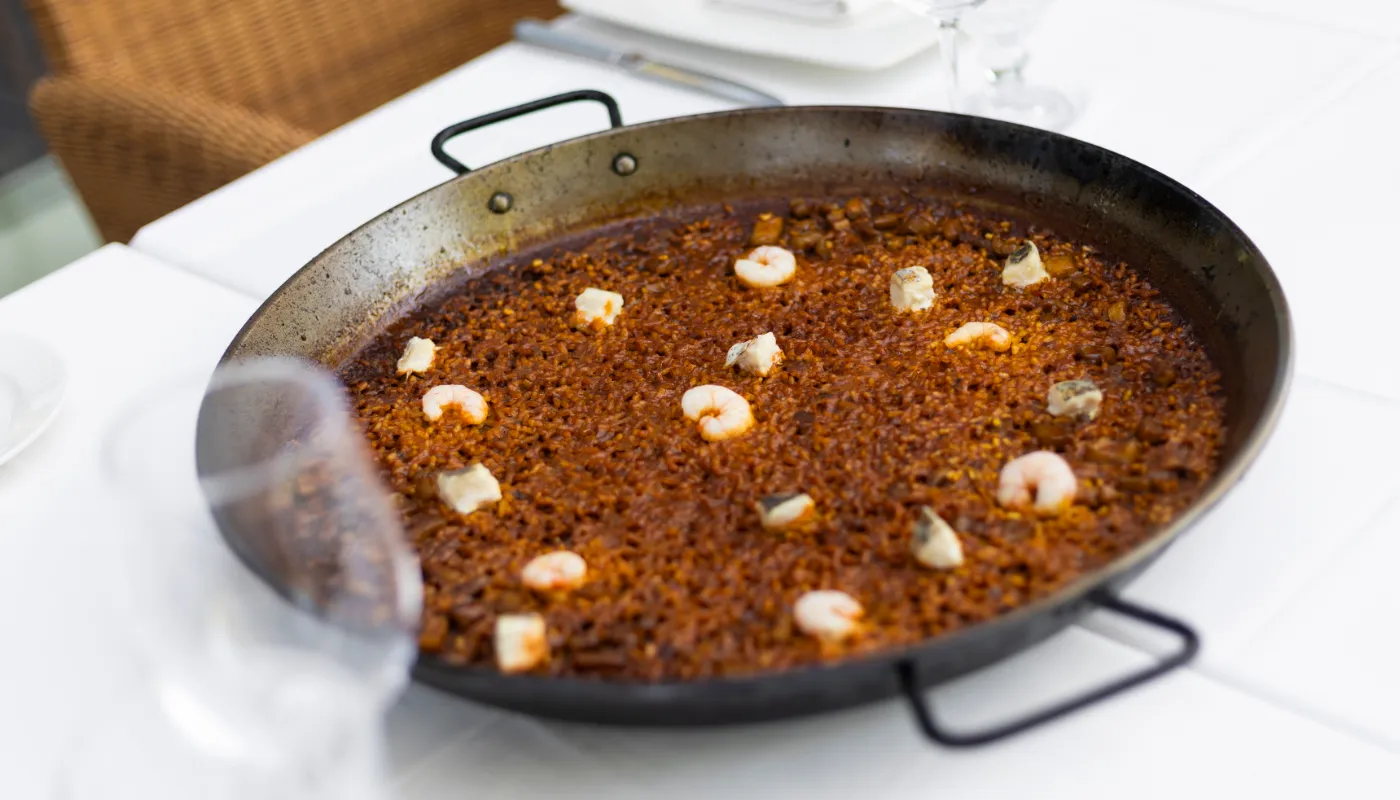 Paella en sart&eacute;n con mariscos y especias, con gambas y trozos de ajo
