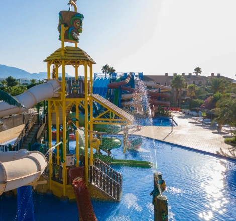Parque acu&aacute;tico con toboganes y piscinas bajo un cielo despejado.