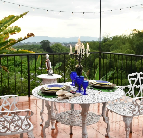 Mesa blanca decorada al aire libre con vista a la naturaleza.