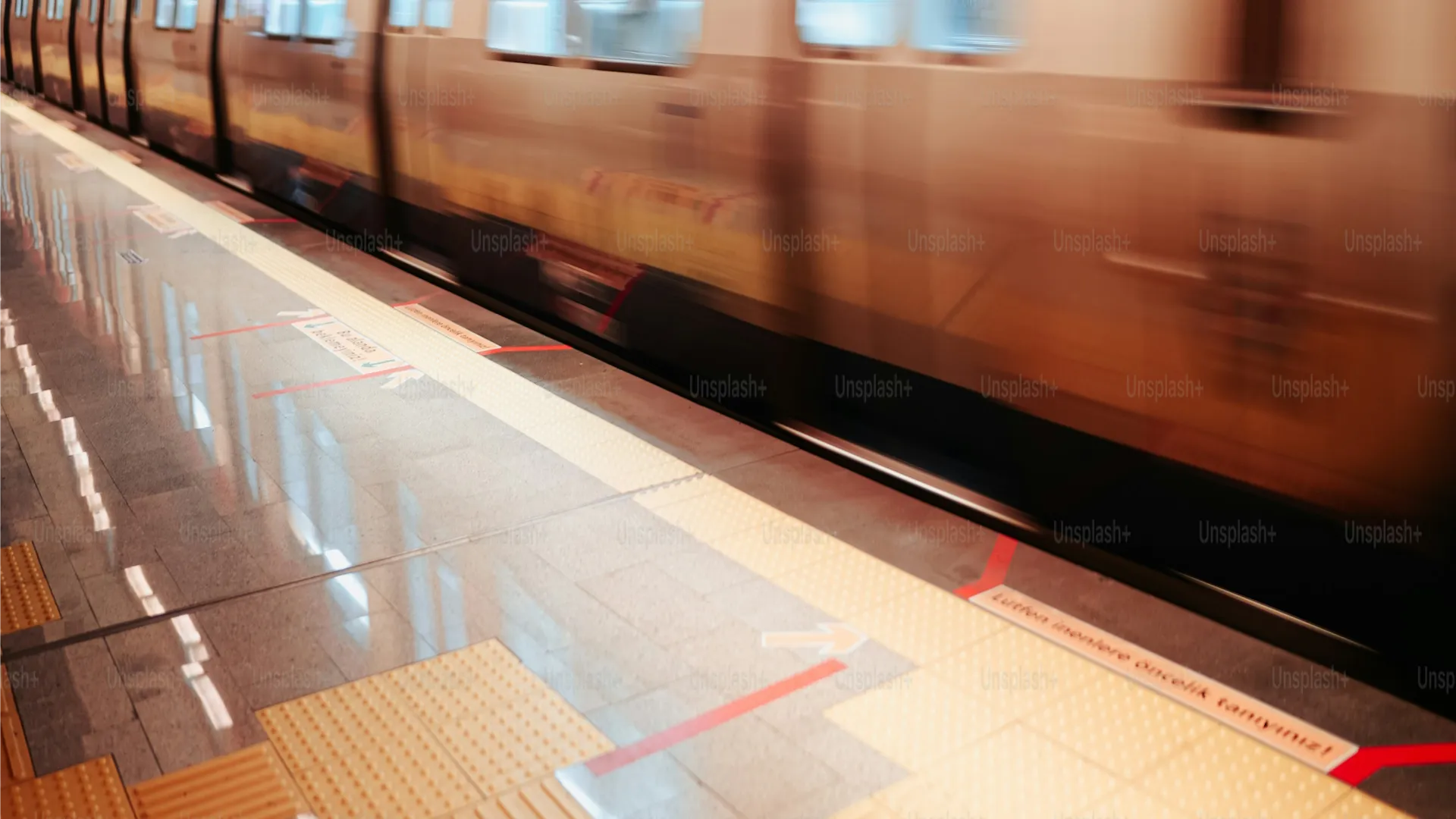 Vista del interior de un metro con v&iacute;a y se&ntilde;alizaci&oacute;n roja y flechas