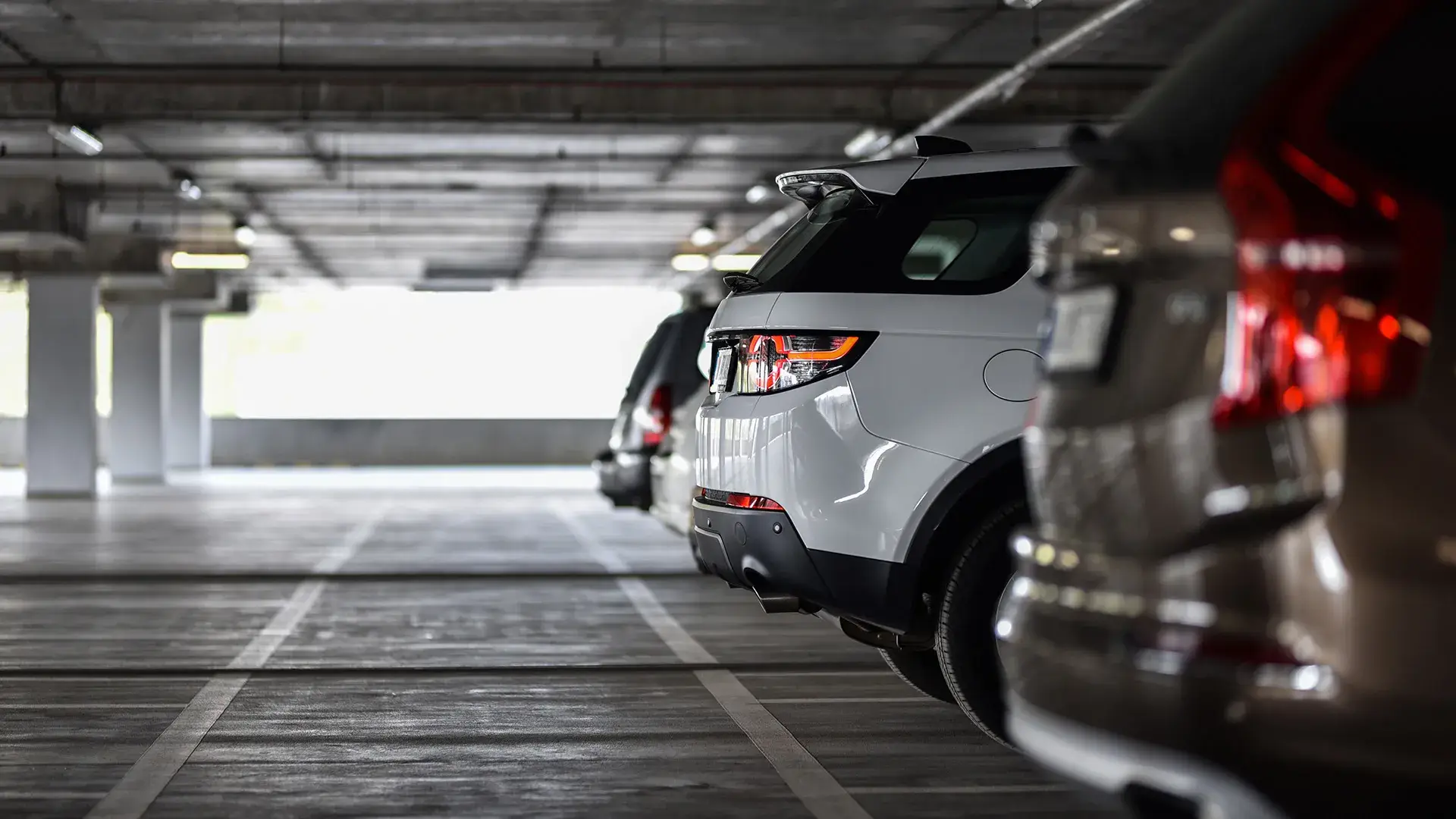 Autos estacionados en un estacionamiento subterr&aacute;neo iluminado.