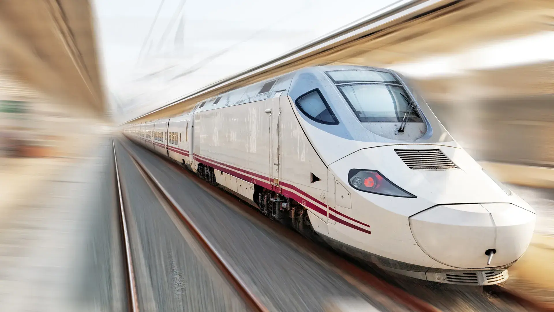 Tren de alta velocidad blanco en movimiento sobre v&iacute;as.