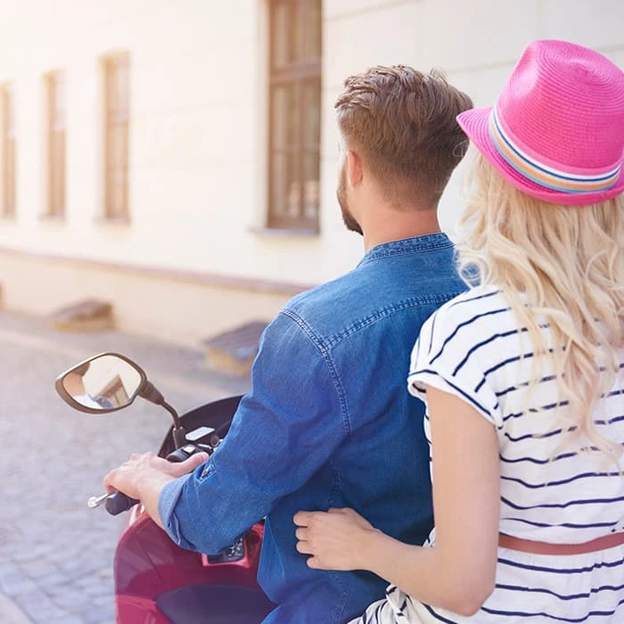 Pareja joven mirando el edificio, la mujer con sombrero rosa.