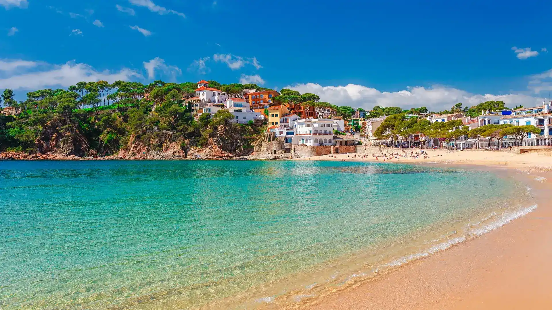 Playa con casas coloridas en la costa y agua cristalina.
