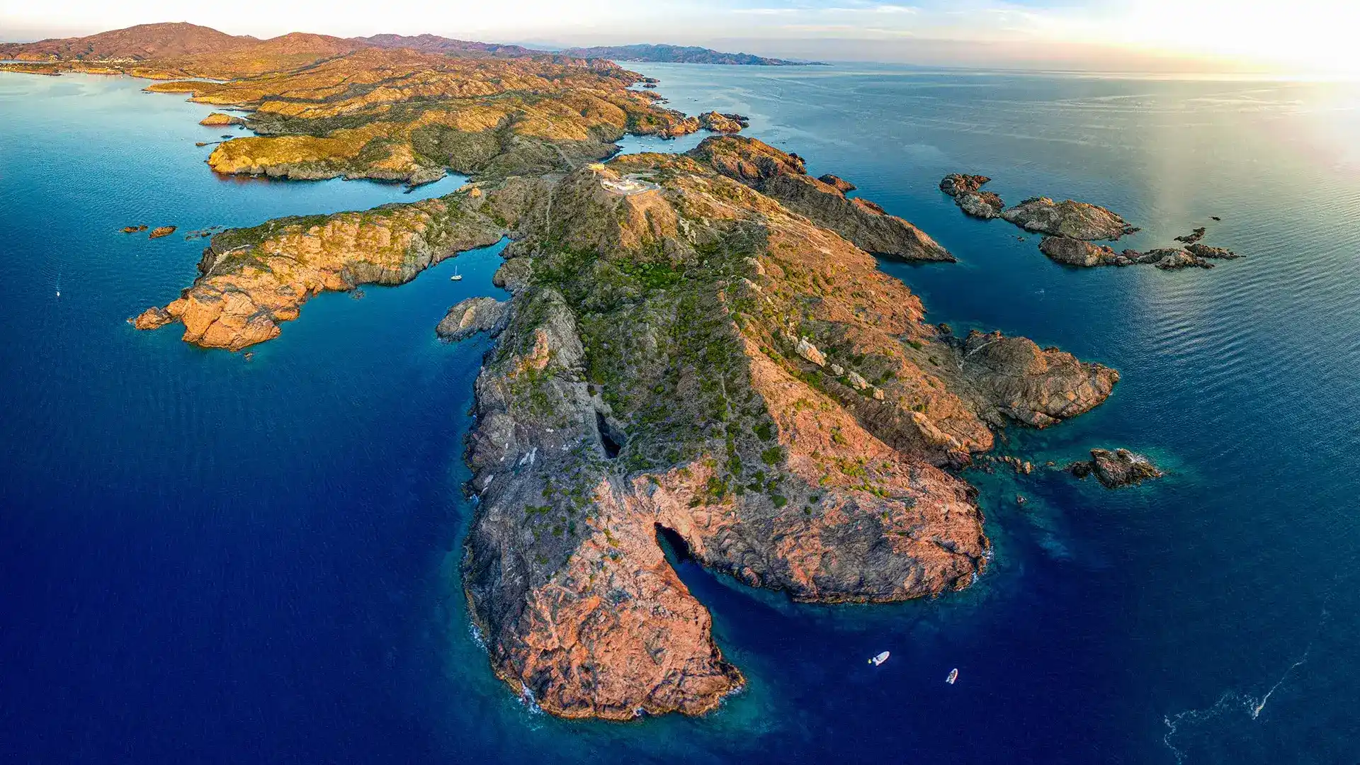 Costa rocosa junto al mar azul en un paisaje monta&ntilde;oso.