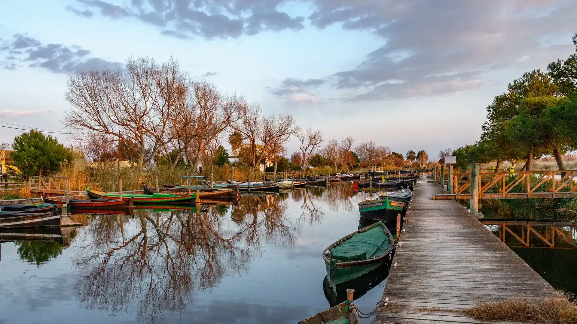 Barcas ancladas junto a un muelle en un d&iacute;a nublado.