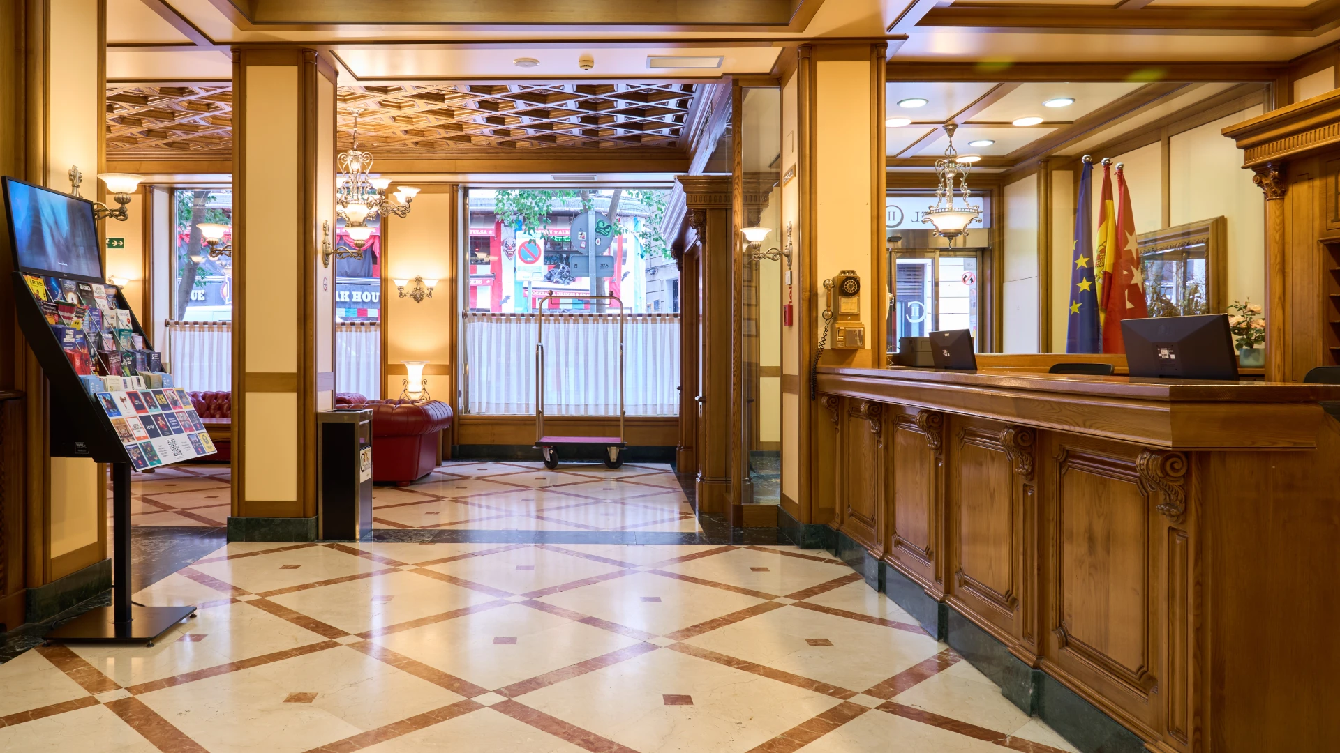 Recepci&oacute;n de hotel cl&aacute;sico con mostrador de madera y decoraci&oacute;n elegante.
